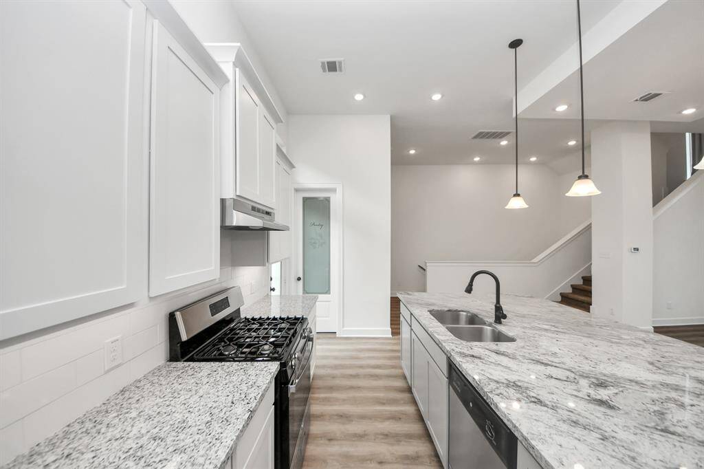 Kitchen includes modern appliances - gas cooktop and electric oven.