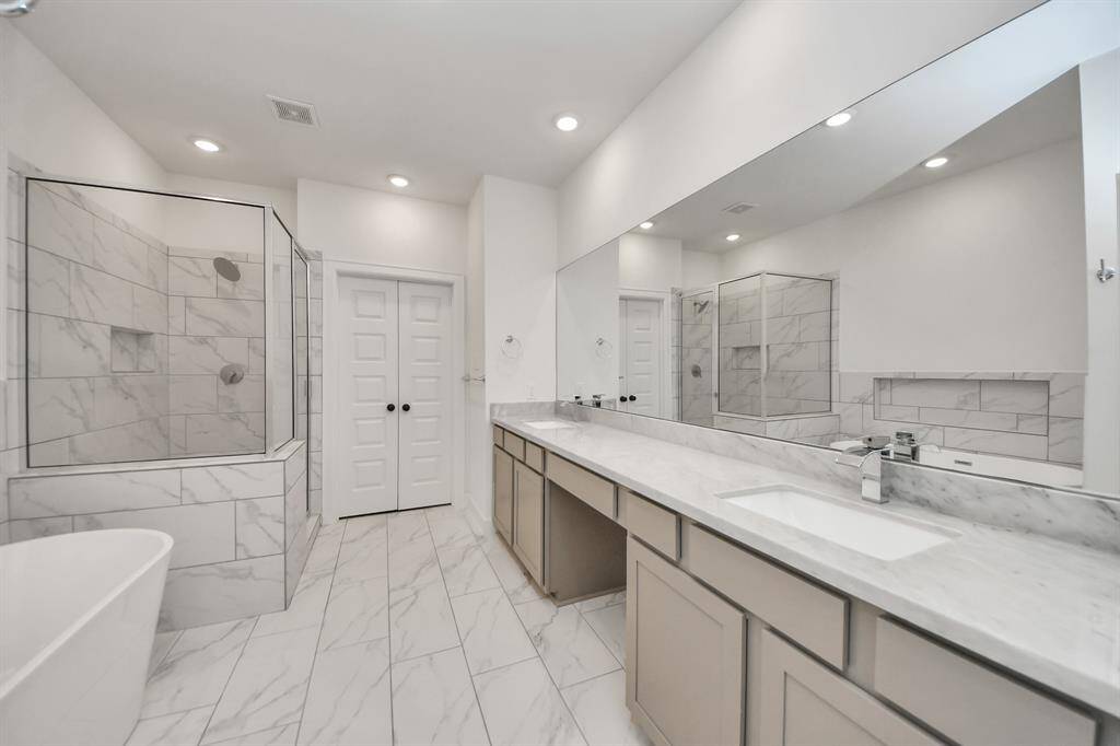The primary bathroom features a spacious double-sink & vanity.