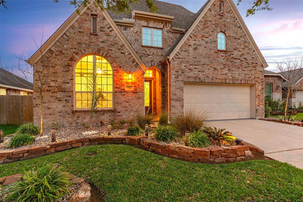 Charming Highland Home Ashwood with well-maintained front yard, featuring an arched entrance and covered front porch. The property includes a double driveway leading to a 3-car garage and Radiant Barrier in the attic for energy efficiency.
