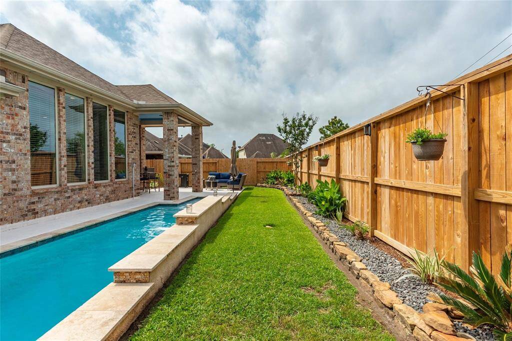 Easy maintenance and carefree landscaping throughout the year. Sprinkler heads are easily seen to avoid damage, fence is extremely secured and attractive solar landspace lights surround. Backyard showcases easily-maintained and professionally-installed landscape and hardscape including solar lights, pavers, rock and stone decking throughout. Recent Pentair Whisperflo High Performance pump. Comfortable outdoor seating area with landscaping creating a relaxing vibe. Attractive surrounding landscape rock.