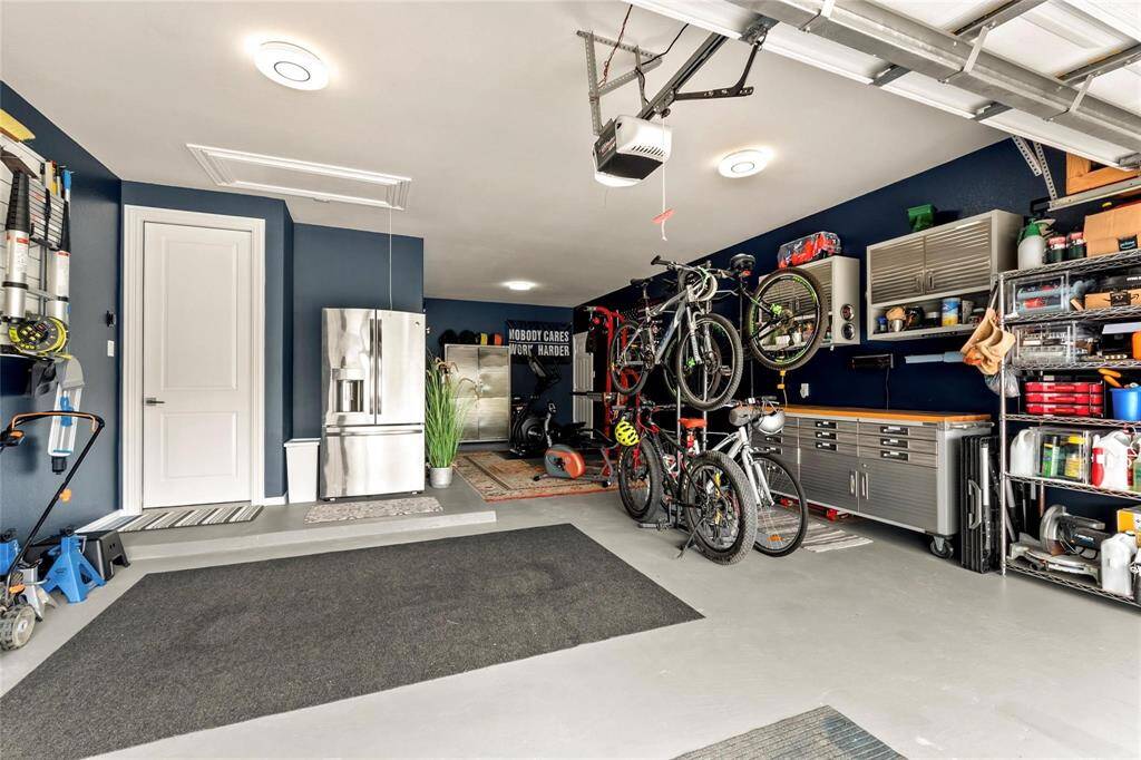 Clean! Spacious! Well-organized! Attractive 3-car tandem garage with fresh paint, LED lights, organizing wall, cabinets and shelves (all included) and an exterior door which leads directly to the backyard. The GE French door refrigerator in the garage conveys. Sprinkler system control mount inside garage.