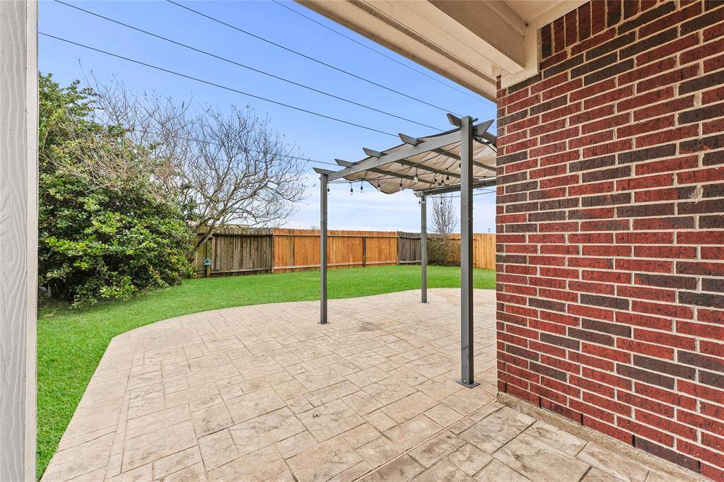 View of the patio from the door to the backyard. The back patio is spacious for entertaining, and features two covered spaces.