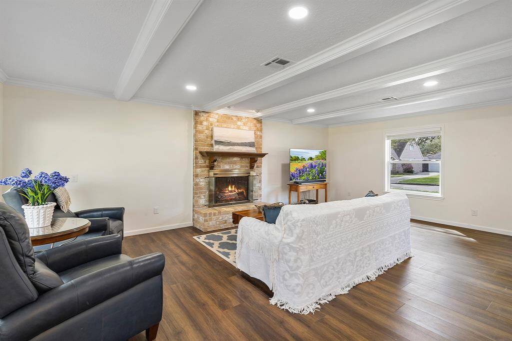 Cozy living area with a warm fireplace and elegant ceiling beams.