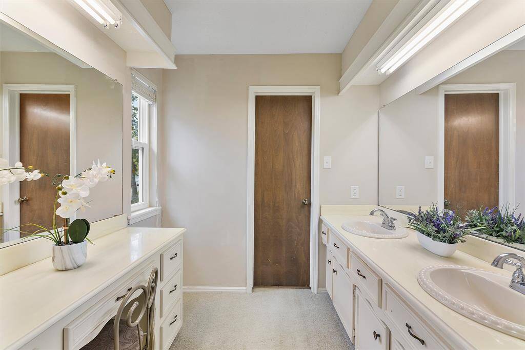 Luxurious primary bedroom ensuite featuring a spacious vanity area and dual sinks for added convenience.