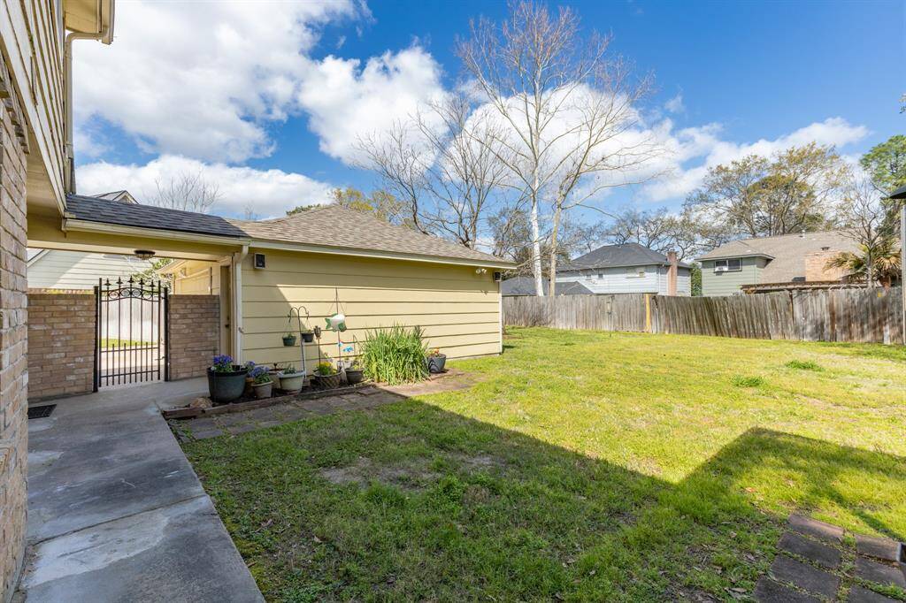 This backyard offers a beautifully maintained lawn with ample space for outdoor activities, complemented by charming garden accents and a private, fenced perimeter.