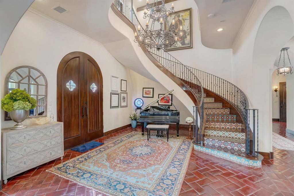 Step into luxury with a stunning spiral staircase and a grand piano as the centerpiece of the entrance.