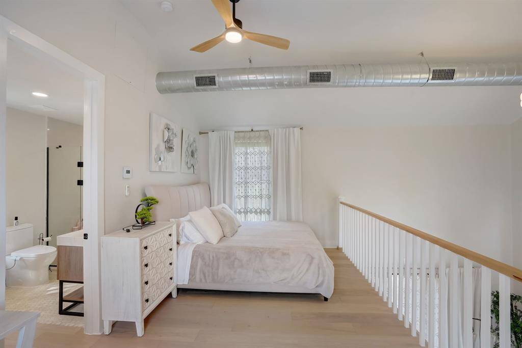 This loft bedroom offers a unique blend of modern design and serene comfort.
