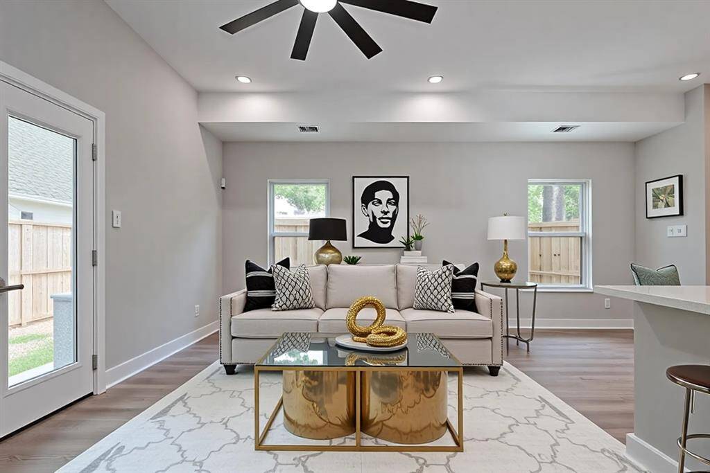 Wall-to-Wall Views and Backyard AccessFramed by large windows and a glass patio door, this living space brings the outdoors in while maintaining total privacy. Crisp walls, sleek baseboards, and a bold ceiling fan complete the modern aesthetic—perfect for customizing your dream living or entertaining zone.