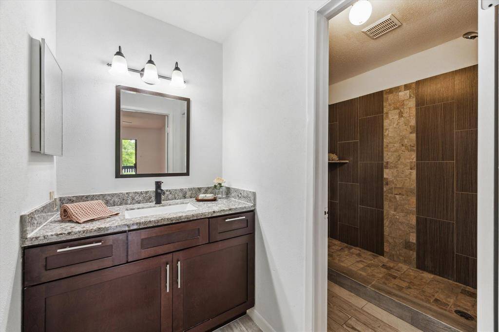 The ensuite bath has been updated, including granite, new cabinetry and a gorgeous and spacious walk in shower Not shown here is the spacious bedroom closet, adding ample storage to this private retreat.