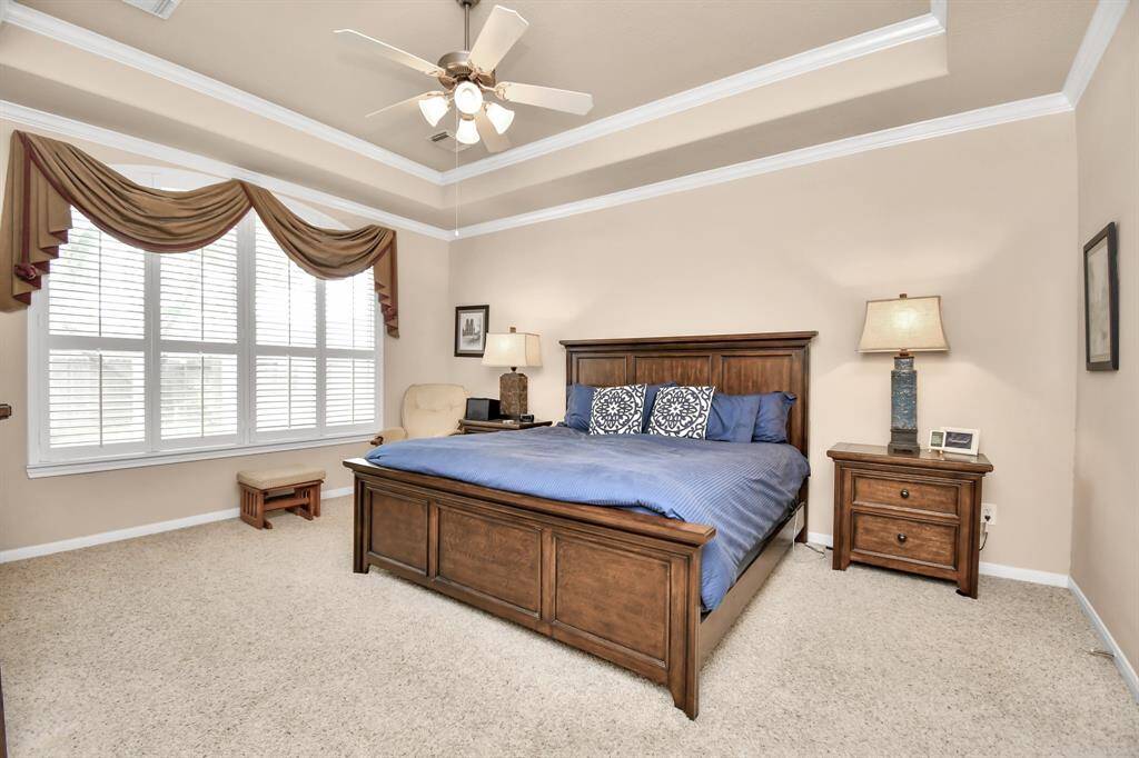 Luxurious touches such as plantation shutters and a trayed ceiling make this primary sanctuary the perfect escape, offering a tranquil and elegant space to relax and rejuvenate.