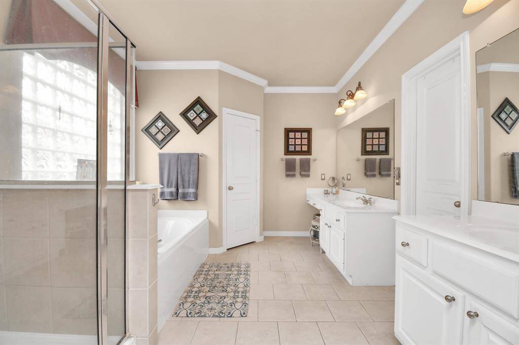 Double doors beckon you into the expansive primary bathroom, offering a spacious setting for both the beginning and end of your day.