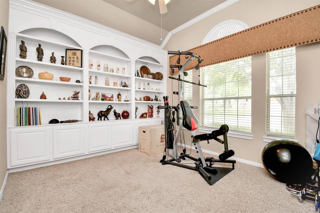 Beyond the French doors awaits a designated study, perfect for those who work from home. A wall of built-ins provides convenient storage, with enough room even for workout equipment.