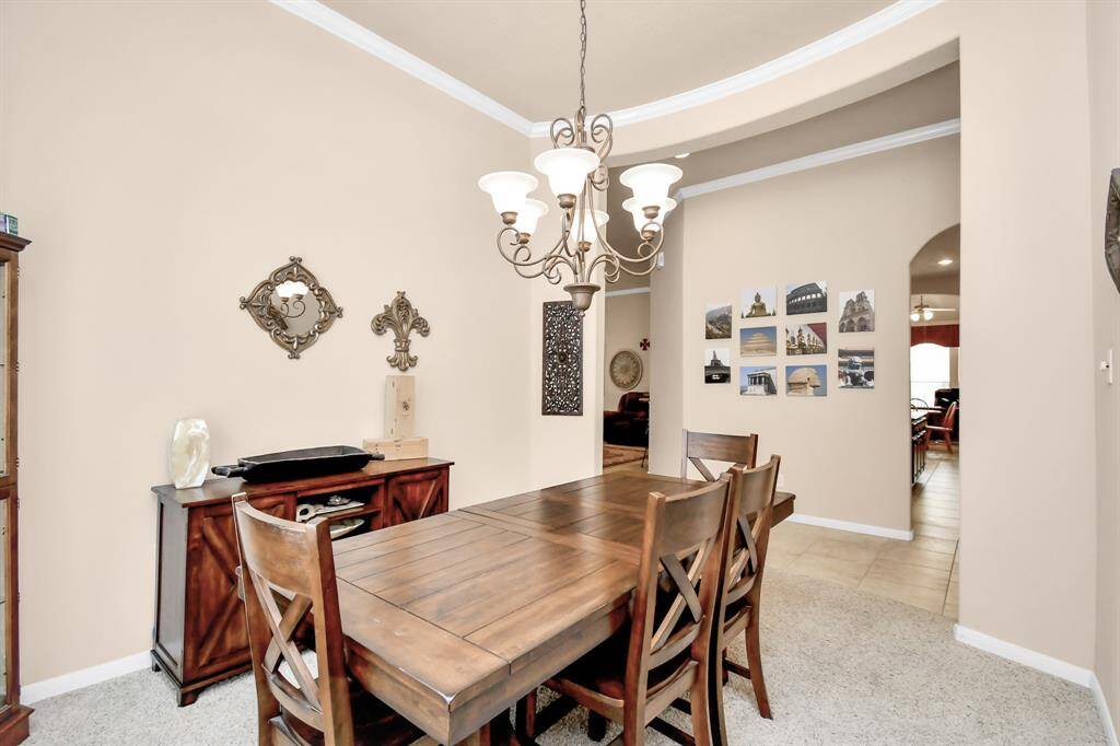 You will appreciate the dining room's convenient location directly across from the kitchen. High ceilings and neutral walls envelop the space, creating an open and airy atmosphere throughout the house.