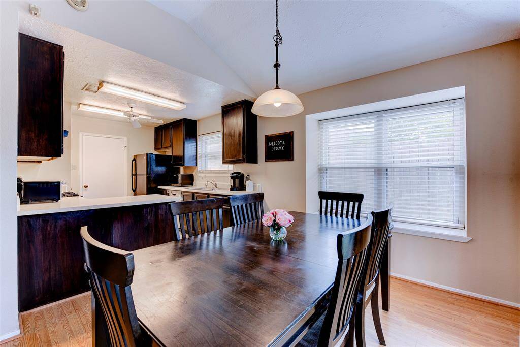 Alternate view of the dining area showcases a large window with a charming sitting ledge that floods the space with natural light. Seamless access to the kitchen makes living and entertaining easy.