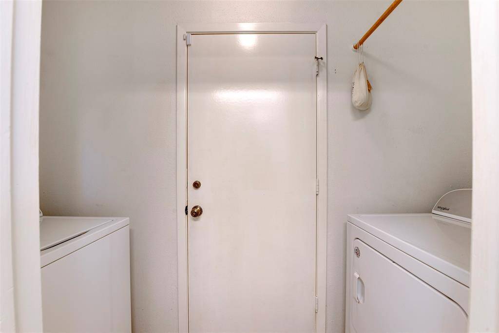 Functional utility room located just before the garage—washer and dryer positioned on opposite sides with added hanging space for convenience and organization.