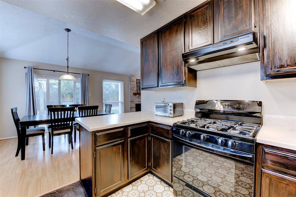 Alternate view of the kitchen showcases additional top and bottom cabinet storage and a gas freestanding range ideal for cooking enthusiasts.