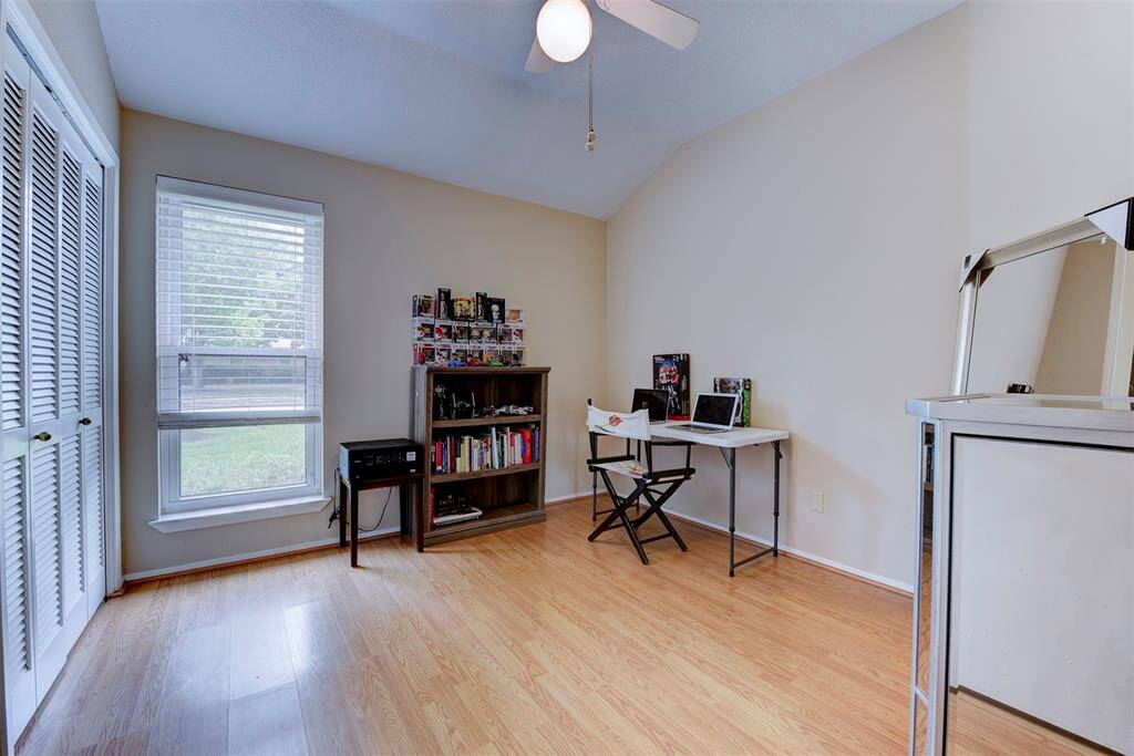 A well-designed secondary bedroom offers an oversized window with charming views of the front yard, filling the space with abundant natural light. A ceiling fan with a light kit adds comfort and convenience, while a generously sized closet provides ample storage.