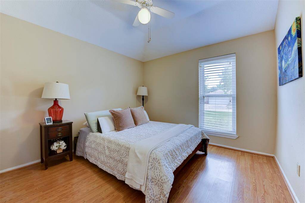 This generously sized secondary bedroom offers a large front-facing window that fills the space with natural light while maintaining a sense of privacy. A roomy closet provides excellent storage, and the sleek vinyl flooring throughout adds both durability and a clean, modern touch.