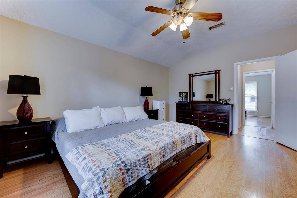 The spacious primary bedroom provides ample room for a variety of furniture configurations. An oversized window floods the space with natural light, which works in combination with the ceiling fan and light kit to create a bright and comfortable retreat within the home.