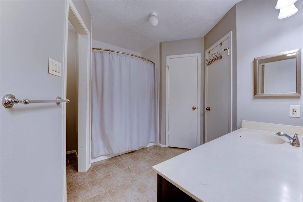 The spacious primary bathroom features a shower and tub combination, and an undermount sink with under-sink storage. A tucked water closet to the side adds extra convenience, completing this well-appointed and functional bathroom.