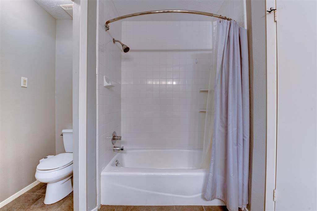 The spacious primary bathroom features a shower and tub combination. A tucked-away water closet adds extra convenience, completing this well-appointed and functional bathroom.