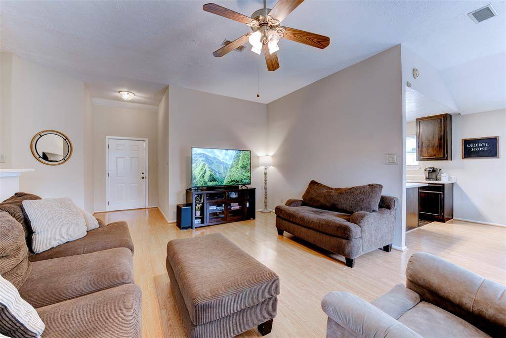 Welcoming foyer with 10-foot ceilings opens to a bright and spacious living area featuring a ceiling fan with light kit and easy access to the kitchen just off to the right.