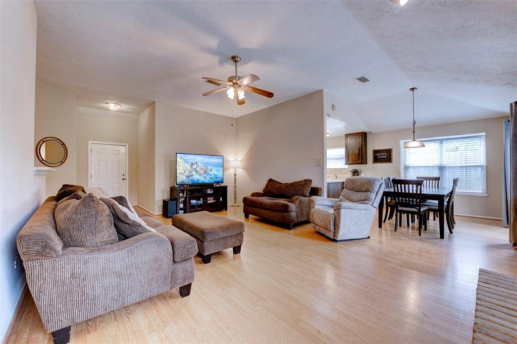 Alternate view showcasing the spacious kitchen to the right, with tall ceilings and oversized windows that flood the open living area with natural light—ideal for everyday comfort and entertaining.
