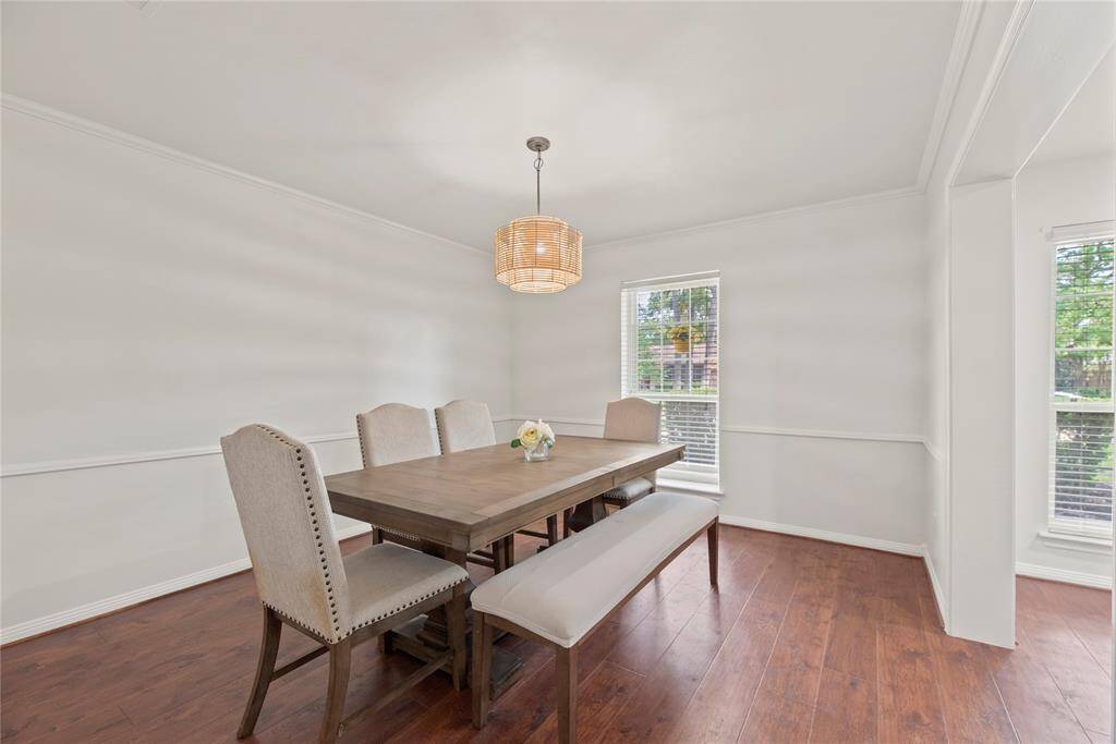 Formal dining room with crown molding, chair rail and modern light fixture.
