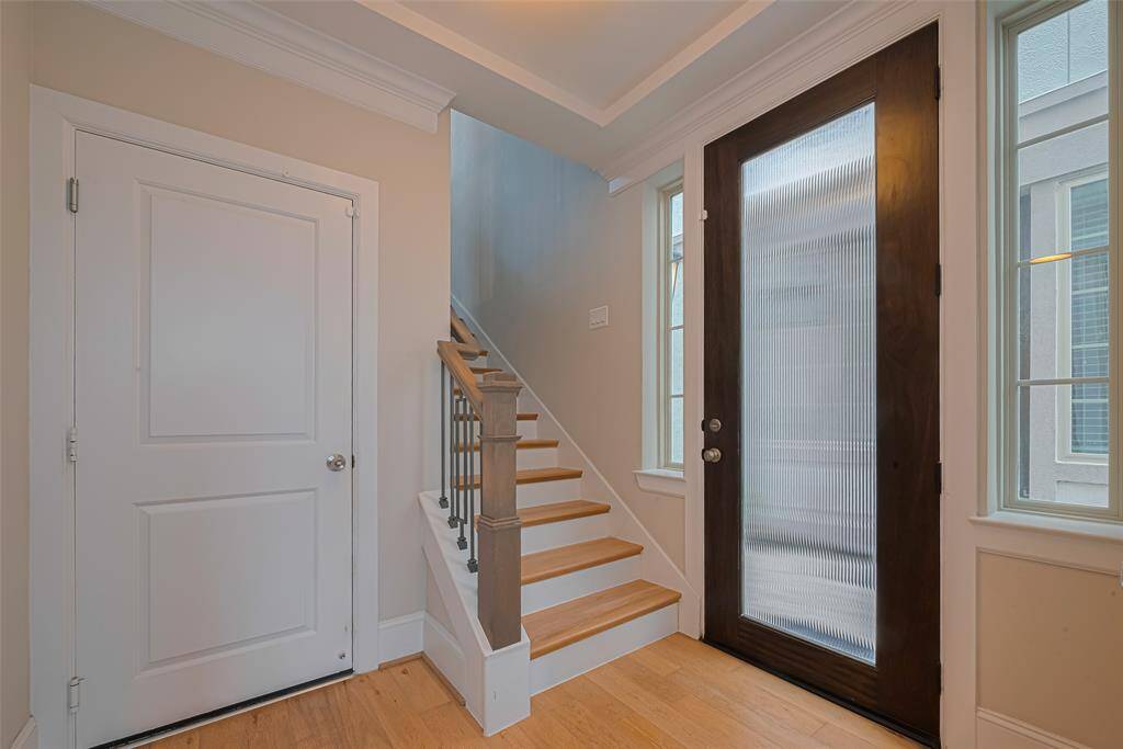 The entrance is absolutely breathtaking! The foyer boasts high ceilings, double crown molding, wide baseboards, iron-wrought stair spindles, gorgeous wooden stairs, and beautiful hardwood flooring that extends throughout the home.