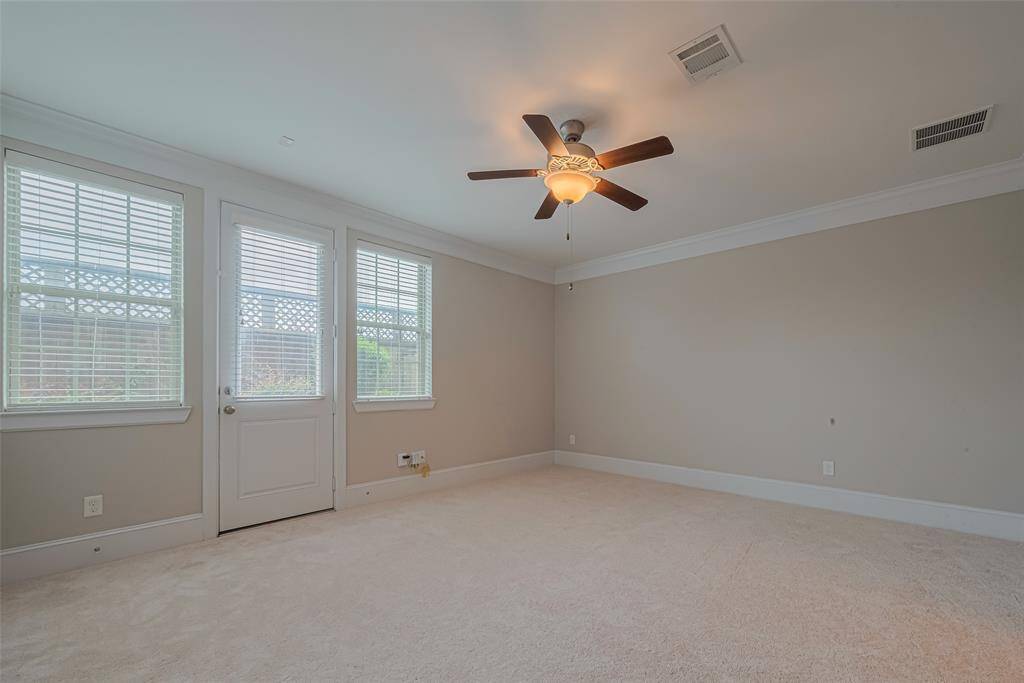 Located on the first floor, this spacious secondary bedroom features brand-new carpeting, elegant double crown molding, a ceiling fan, and stylish faux wood blinds. Enjoy direct access to the backyard through a private door, making this flexible space ideal for use as either a cozy bedroom or a convenient home office.