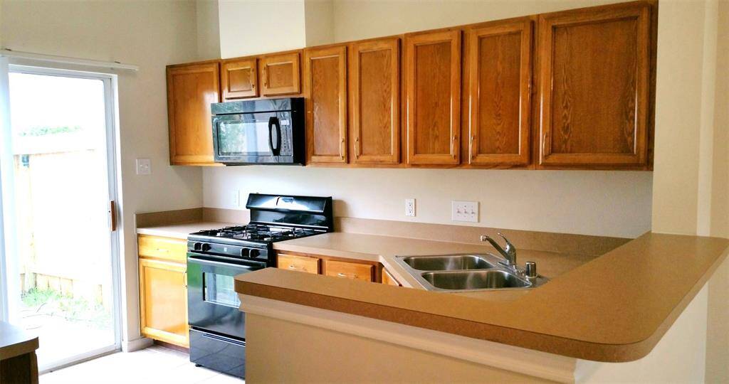 Kitchen with sliding doors to fence backyard.