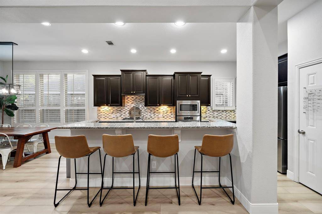 The wide kitchen bar accommodates several stools, providing a perfect spot for casual dining or entertaining guests.
