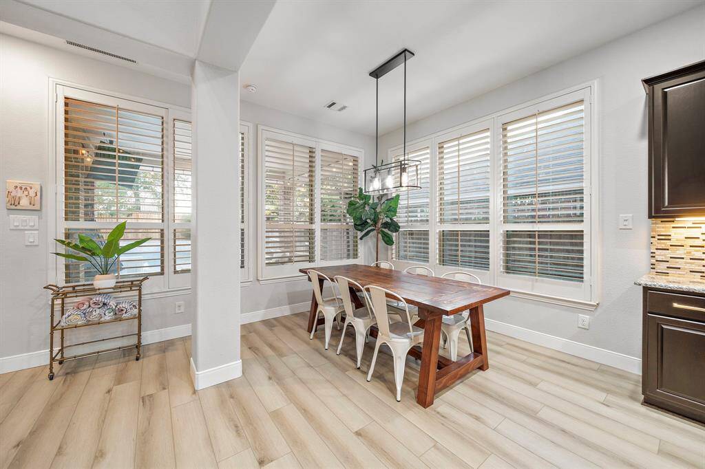 The dining nook offers an abundance of natural light through expansive windows, creating a bright and airy atmosphere, perfect for family meals or entertaining.