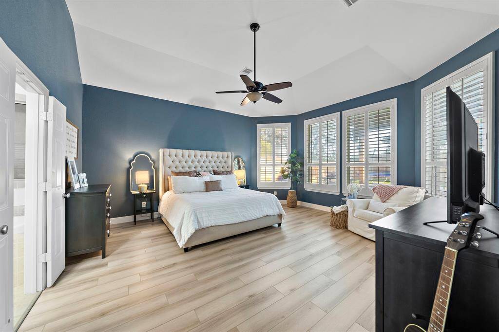 The primary bedroom offers a spacious layout with a vaulted ceiling and bay window, enhancing the room’s open and airy feel.