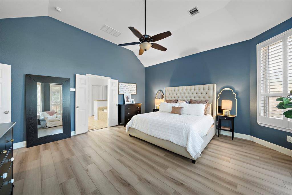 This expansive primary bedroom features large windows that allow natural light to fill the room, creating a serene retreat.