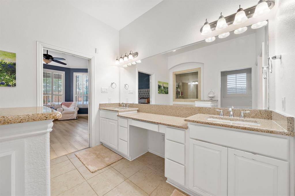 The primary bathroom offers dual vanities, a large walk-in shower, and a relaxing soaking tub, all within a spacious and modern design.