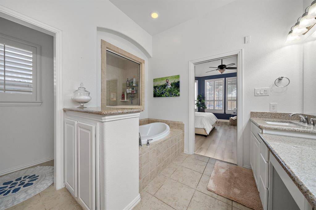 The spacious walk-in shower, accented with neutral tiles, complements the bathroom’s granite countertops and provides a tranquil, spa-like environment.
