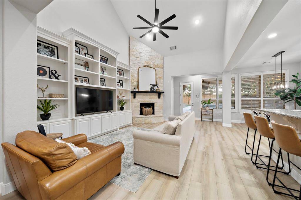 Spacious open-concept living room with vaulted ceilings, perfect for entertaining. Built-in shelving adds both functionality and style, perfect for displaying décor and personal touches.