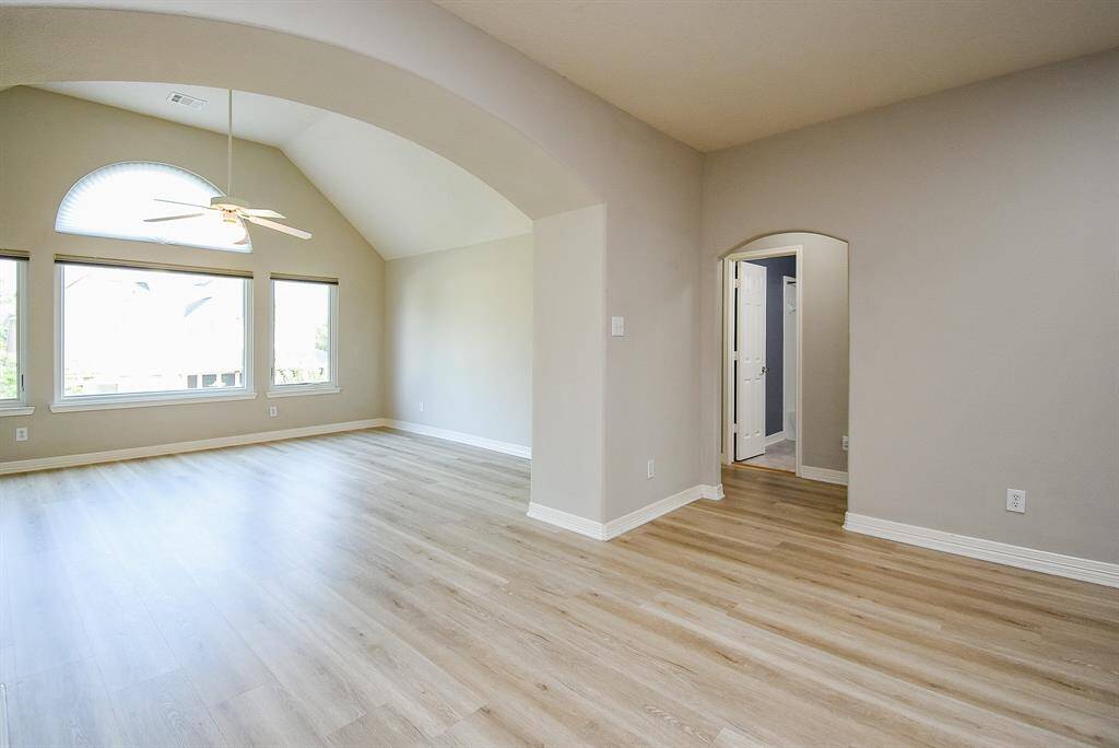 Upstairs game room with arched entry, new vinyl wood flooring throughout the upstairs living area. Wall of picture windows and arched accented windows brings in tons of natural light.  All new ductwork upstairs!