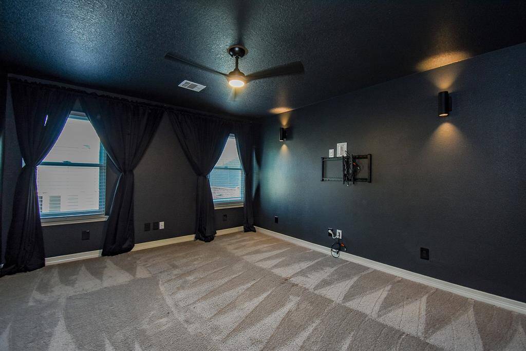 Secondary bedroom has been converted into a media room with sconces, blackout drapes and dark paint.  Movie night anyone!
