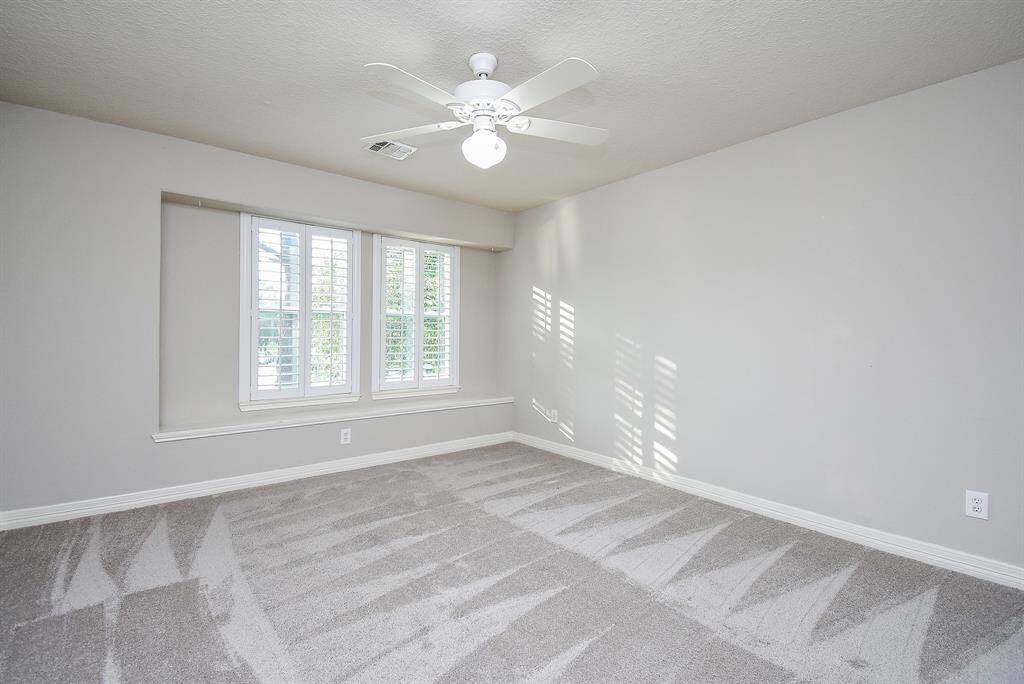 Another secondary bedroom upstairs with light colored carpet and paint. All secondaries have ceiling fans.