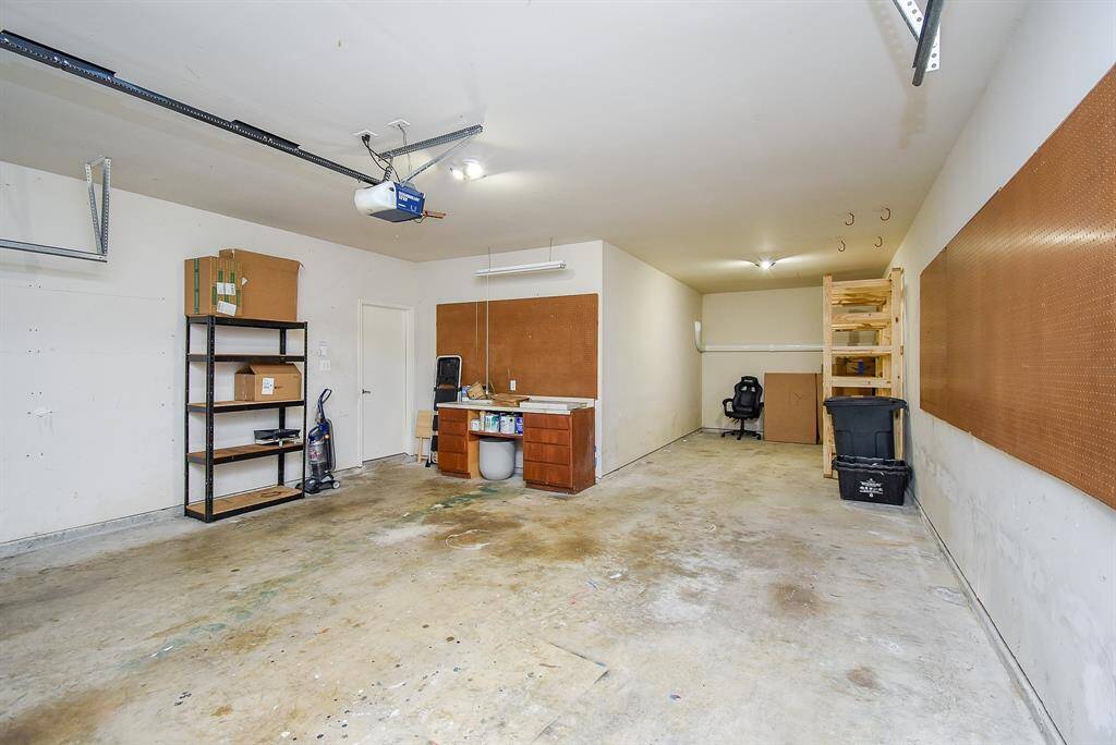 Oversized three car garage with built in shelves for storage.