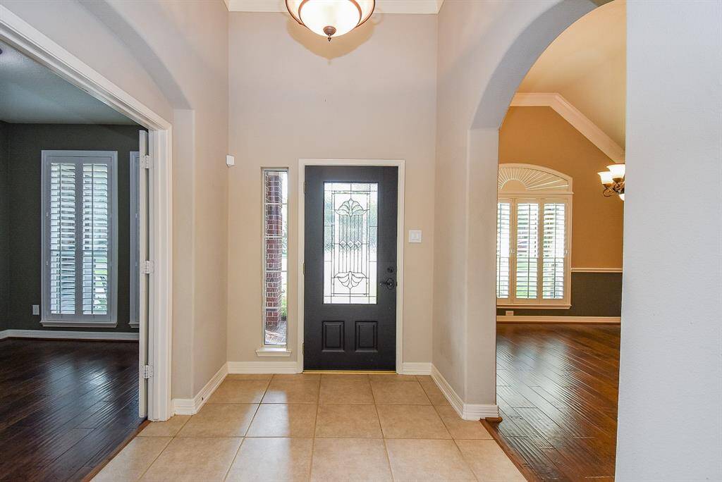 The inviting entry way is illuminated with chandelier and recessed lighting.