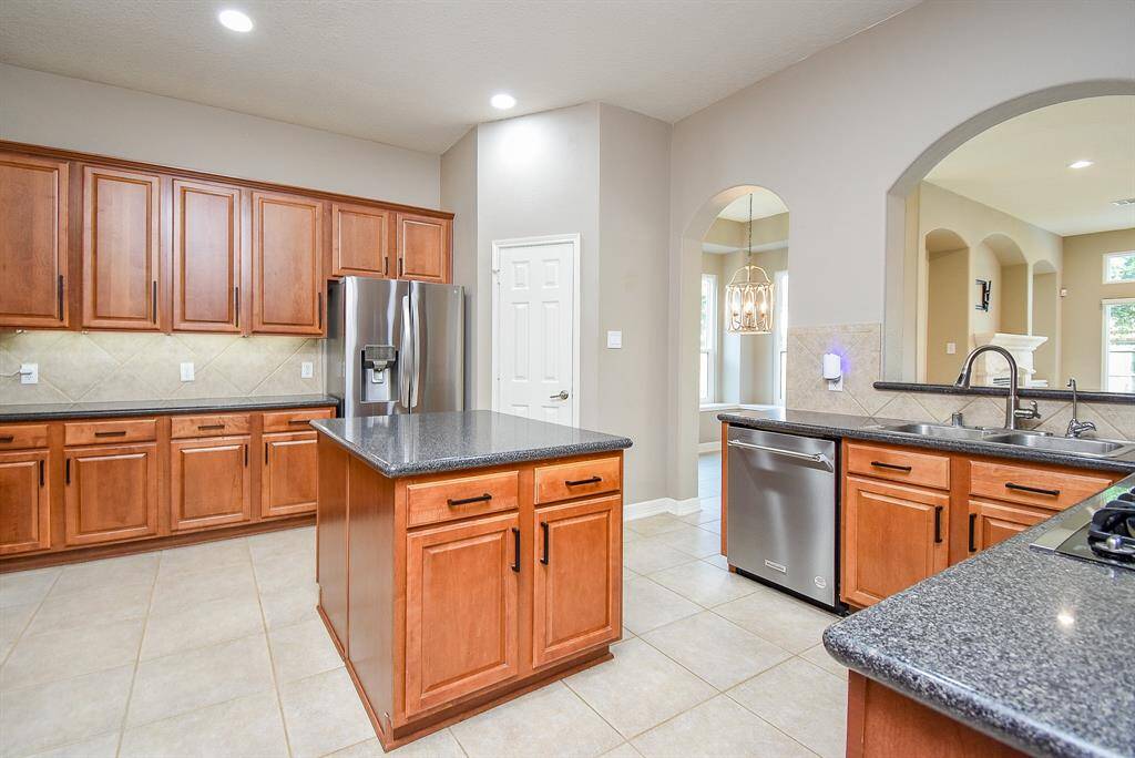 Oversized kitchen with large light-colored tile open to breakfast area and family room. Tons of cabinets, drawers and counter space - every Chef's dream!