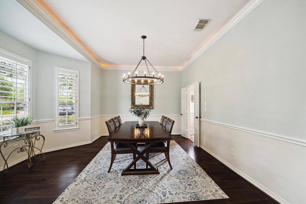 Rich, dark hardwood flooring contrasts beautifully with the soft, neutral walls, creating a warm and inviting atmosphere perfect for entertaining.