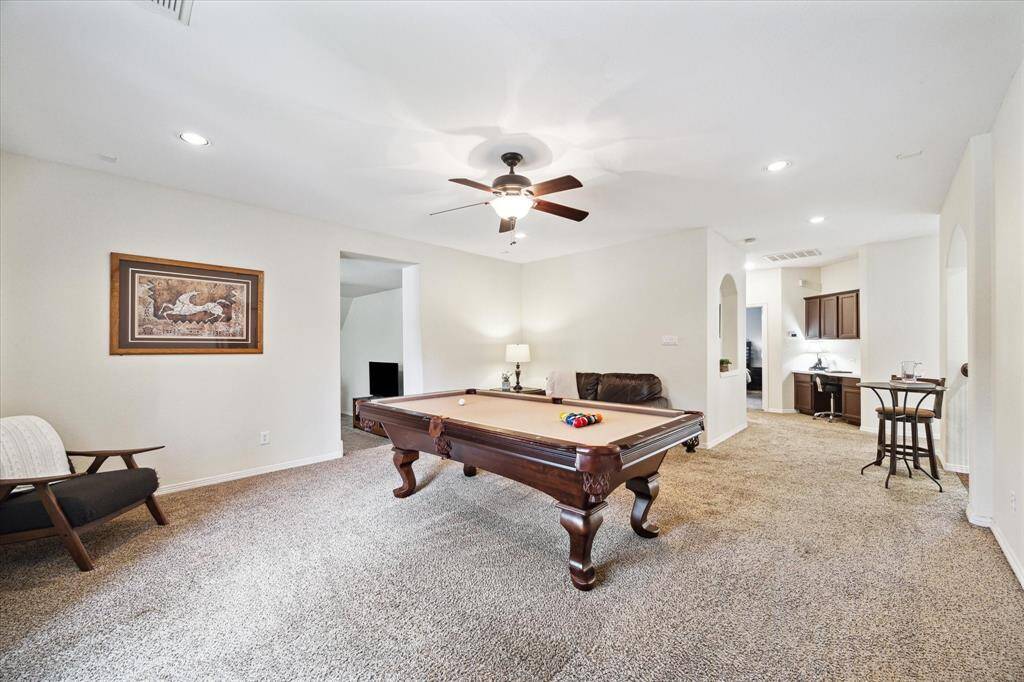 Spacious upstairs game room featuring a wall of windows that fills the space with natural light, creating a bright and inviting atmosphere. Plush carpeting adds warmth and comfort underfoot, while the included pool table makes it the perfect spot for entertaining or relaxing with family and friends. There is also two large attics offering lots of storage space for all those holiday decorations!
