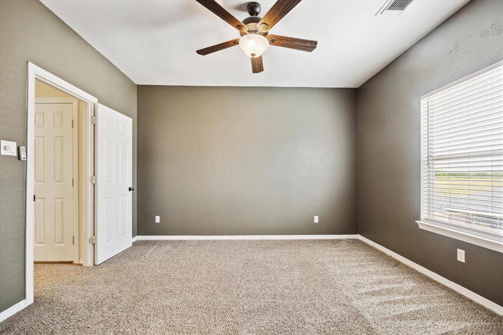 Second of three upstairs bedrooms showcasing fresh decorative paint and plush carpeting for a cozy, updated feel.