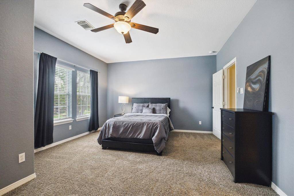 Spacious third upstairs bedroom featuring a generous layout and a walk-in closet for ample storage. A comfortable and versatile space, ideal for a guest suite or teen retreat.