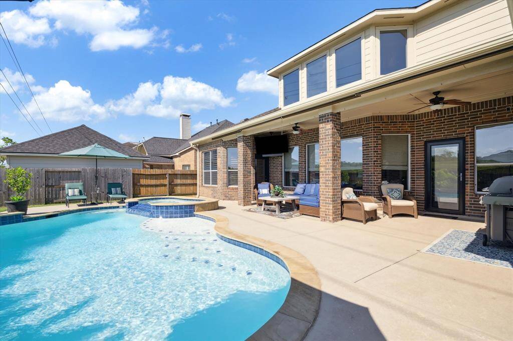 When it is time to unwind, step outside to your covered patio overlooking the pool and spa. Time to fire up the grill!