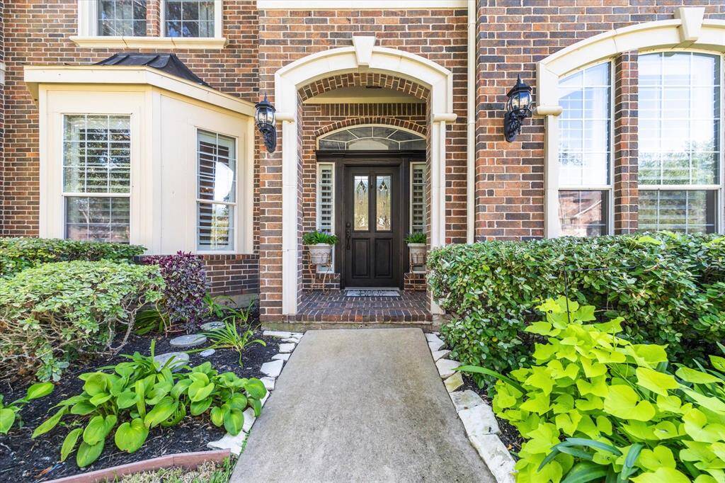 Front entry with arched brick detailing welcomes friends and family as they approach the home.